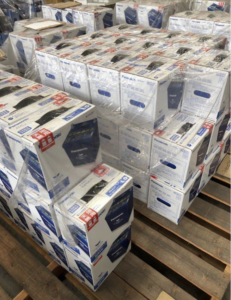 パレット上に積み上げられた大量のパナソニックカオスバッテリー。在庫管理された新品カーバッテリーの保管風景。